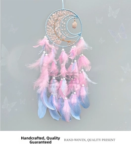 Detail of handmade moon dreamcatcher with pink feathers and natural crystal tree