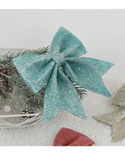 Close-up of sparkling turquoise Christmas bow with sequins on festive pine tree branches