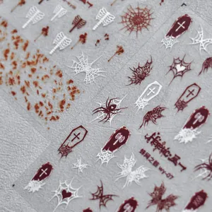 Close-up of Halloween nail decals featuring spider webs, coffins, and dark red skeletons