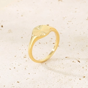Macro di anello a sigillo con girasole placcato oro 18K su superficie in pietra