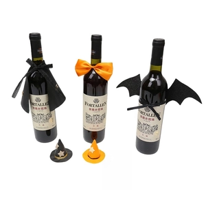 Miniature witch hats and capes decorating wine bottles for Halloween party settings