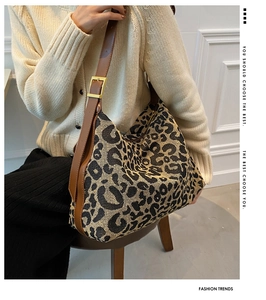 Detail of adjustable leather strap with golden square buckle on leopard print tote
