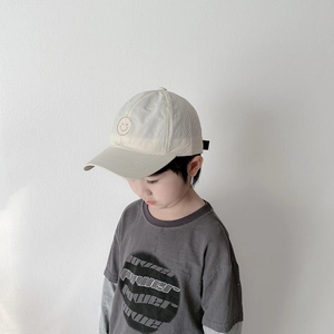 Détail de la casquette de baseball en mesh beige avec broderie smiley et t-shirt gris