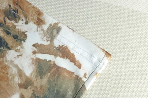 Detail of camouflaged tie-dye print dress showing double-needle stitching and knit texture