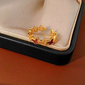 Macro detail of a 18k gold plated butterfly open ring with red enamel details