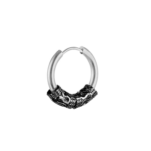 Detailed macro view of vintage stainless steel hoop earring with black dragon scale carvings