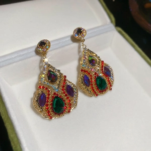Detailed macro view of vintage gold drop earrings with colorful crystals in a gift box
