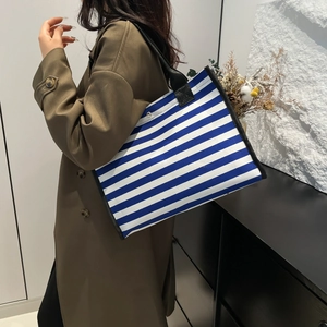 Minimalist blue and white striped canvas tote bag with black handles for daily commuting