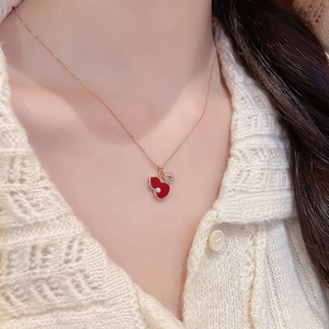 Detail of red enamel gourd pendant necklace with zircon on a rose gold chain
