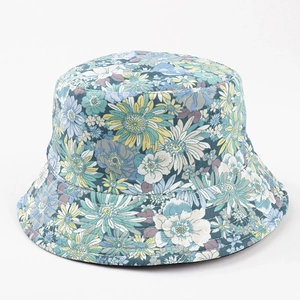 Detail of floral bucket hat with dense blue, green and yellow pattern on white base