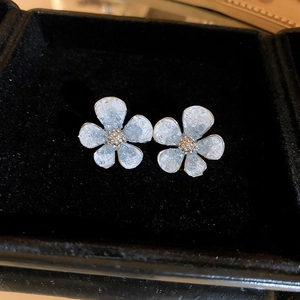 Macro shot of blue crystal flower earrings with ice-cracked texture on black velvet