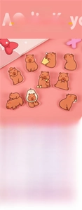 Close-up of cute acrylic capybara brooches in various poses on a pink background