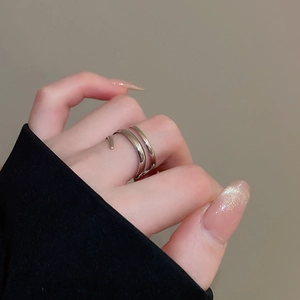 Polished silver double-layer open ring shown on finger with minimalist hollow line design
