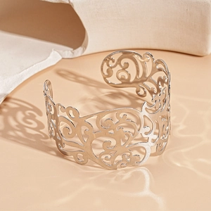 Detail of silver hollowed-out floral ginkgo leaf cuff bracelet with intricate patterns