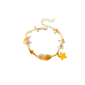 Handmade woven bracelet with amber cat charm and yellow star pendant on white background