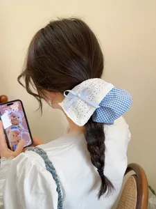 Detail of blue plaid and lace bow scrunchie with pearl on a hairstyle