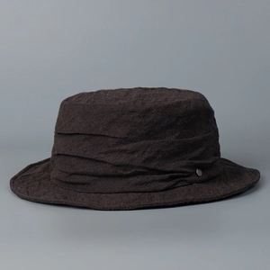 Close-up of a charcoal grey linen fisherman hat with pleated crown and metal detail