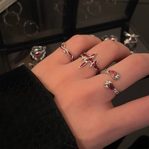 Macro shot of silver stackable rings with red teardrop stones and enamel on finger