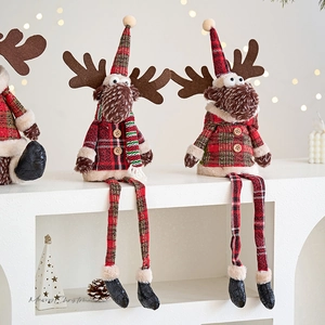 Plush Christmas reindeer dolls in red and green plaid outfits on white shelf with bokeh