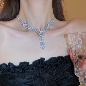 Detail of silver leaf pendant necklace with shimmering cubic zirconia on elegant model