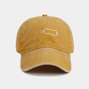 Close-up of mustard yellow washed cotton cap with 1% low battery embroidery detail