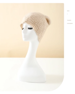 Detail of soft beige knit cashmere beanie with intricate cable stitch pattern