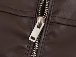 Detail of dark brown vintage faux leather jacket showing metal zipper and stitching
