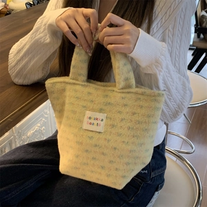 Detailed texture of fluffy light yellow plush handbag with colorful polka dot accents