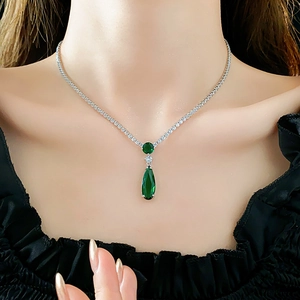 Close-up of teardrop green zircon necklace with silver chain on model neck