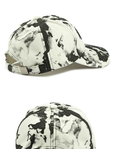 Détail de casquette tie-dye avec motif d'éclaboussures d'encre noire et boucle métal