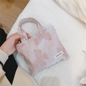 Detail of lavender mini tote bag with pink bow jacquard and simple wish brand label