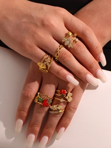 Detail of 18k gold plated stainless steel rings with enamel strawberry and bug designs