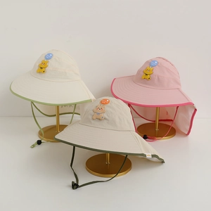 Detailed view of children's sun hats with wide brims, neck flaps and cute bear badges