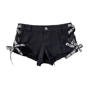 Dettaglio di hot pants in denim nero con frange rovinate e allacciatura con nastro LOVE