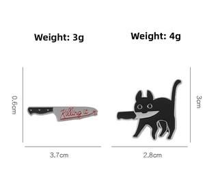 Detail of funny enamel cat holding knife pins with Killing It text on white background