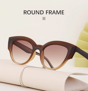 Brown gradient cat-eye sunglasses placed on a minimalist beige pouch with round frame