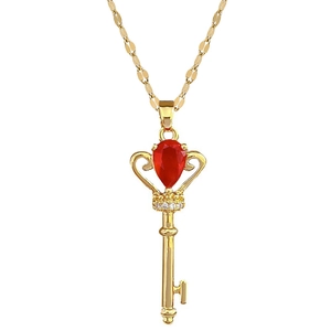 Elegant gold crown key necklace with a red teardrop gemstone and sparkling diamonds