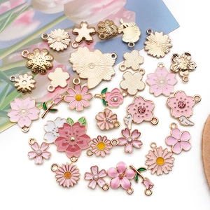 Detailed flat lay of pink cherry blossom alloy charms with enamel for DIY jewelry making