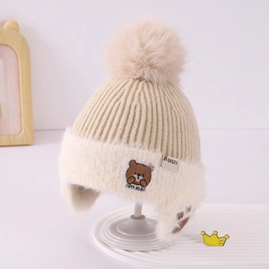Close-up of the plush fleece lining and cute bear embroidery on the kid's winter knit hat