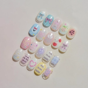 Macro shot of Japanese style press-on nails with cute hand-drawn puppies and bow patterns