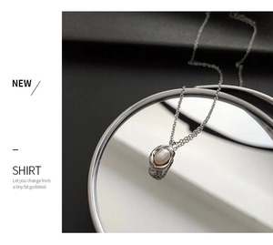 Detailed macro view of irregular silver-wrapped pearl pendant on a sleek chain