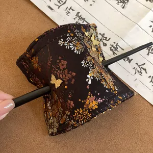 Close-up of vintage Chinese style embroidered fabric hair pin with golden butterfly details
