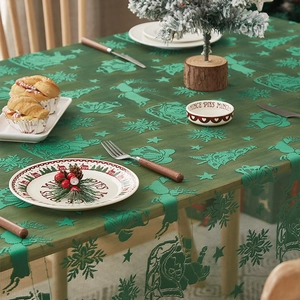 Detail der grünen Weihnachts-Spitzentischdecke mit Rentier- und Schneeflockenmuster