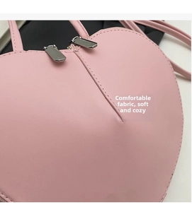 Dettaglio della borsa rosa a forma di cuore con doppie cerniere e pelle PU di qualità