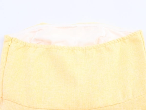 Dettaglio del tessuto tweed giallo con fodera interna e cerniera invisibile laterale