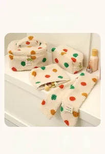 Close-up of plush polka dot cosmetic bag set including pouch and fuzzy headband