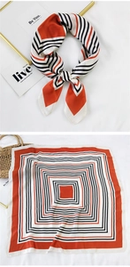 Detail of silk scarf showing square geometric stripes and knotted styling on white background
