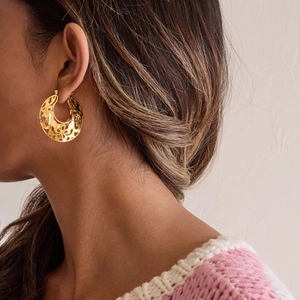 Boucles d'oreilles dorées style vintage français avec motifs floraux sur un modèle