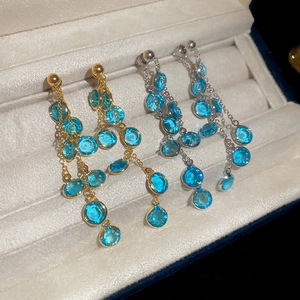 Dettaglio di orecchini a frangia placcati oro 18k con perline di vetro blu cielo