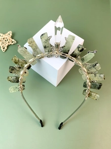 Close-up of handmade silver wire crown with green spotted stones and crystal